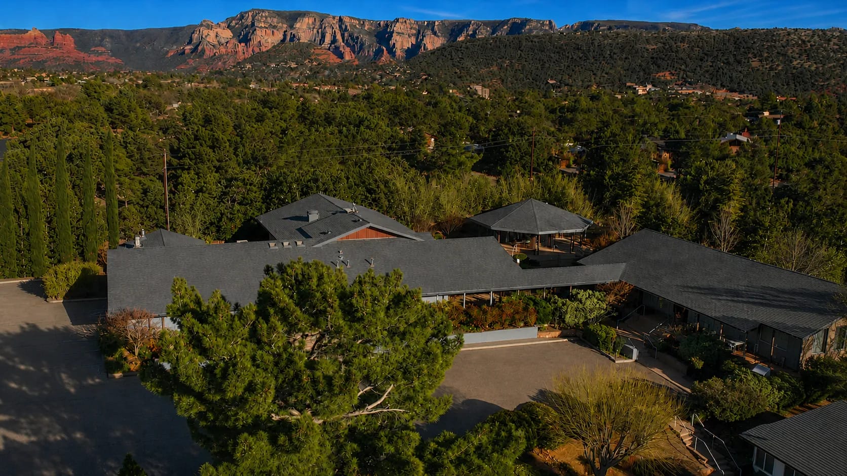 Aerial view of Sedonya surrounded by trees beneath Sedona's red rock formations