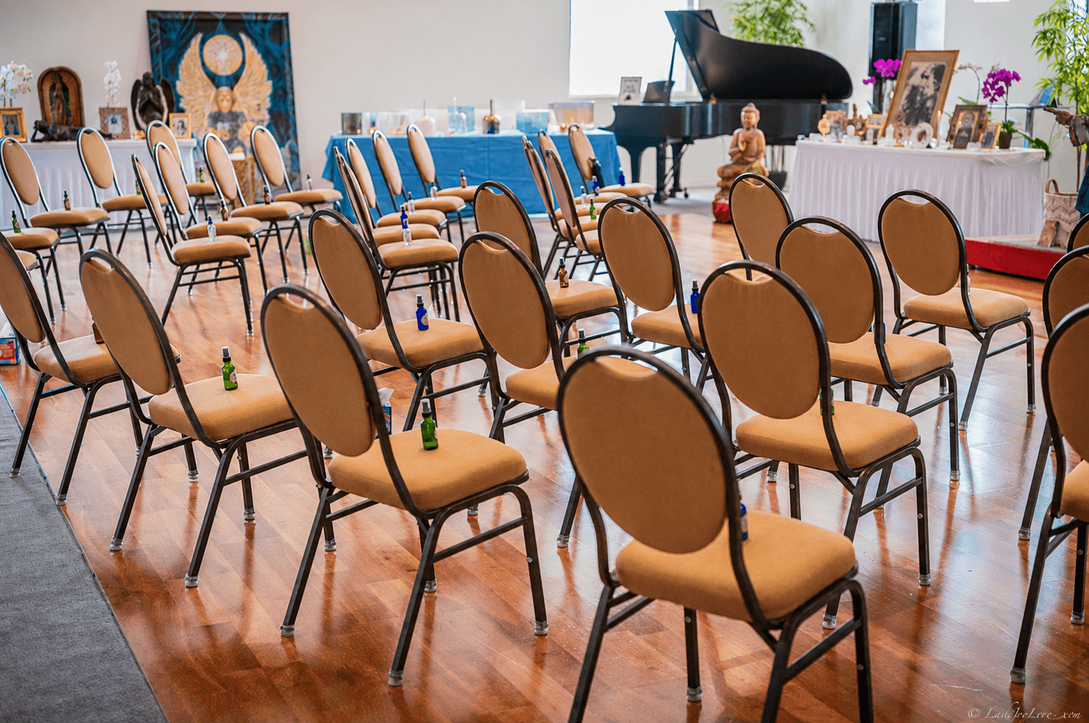 Rows of seating drawn before the altar, Buddha and grand piano