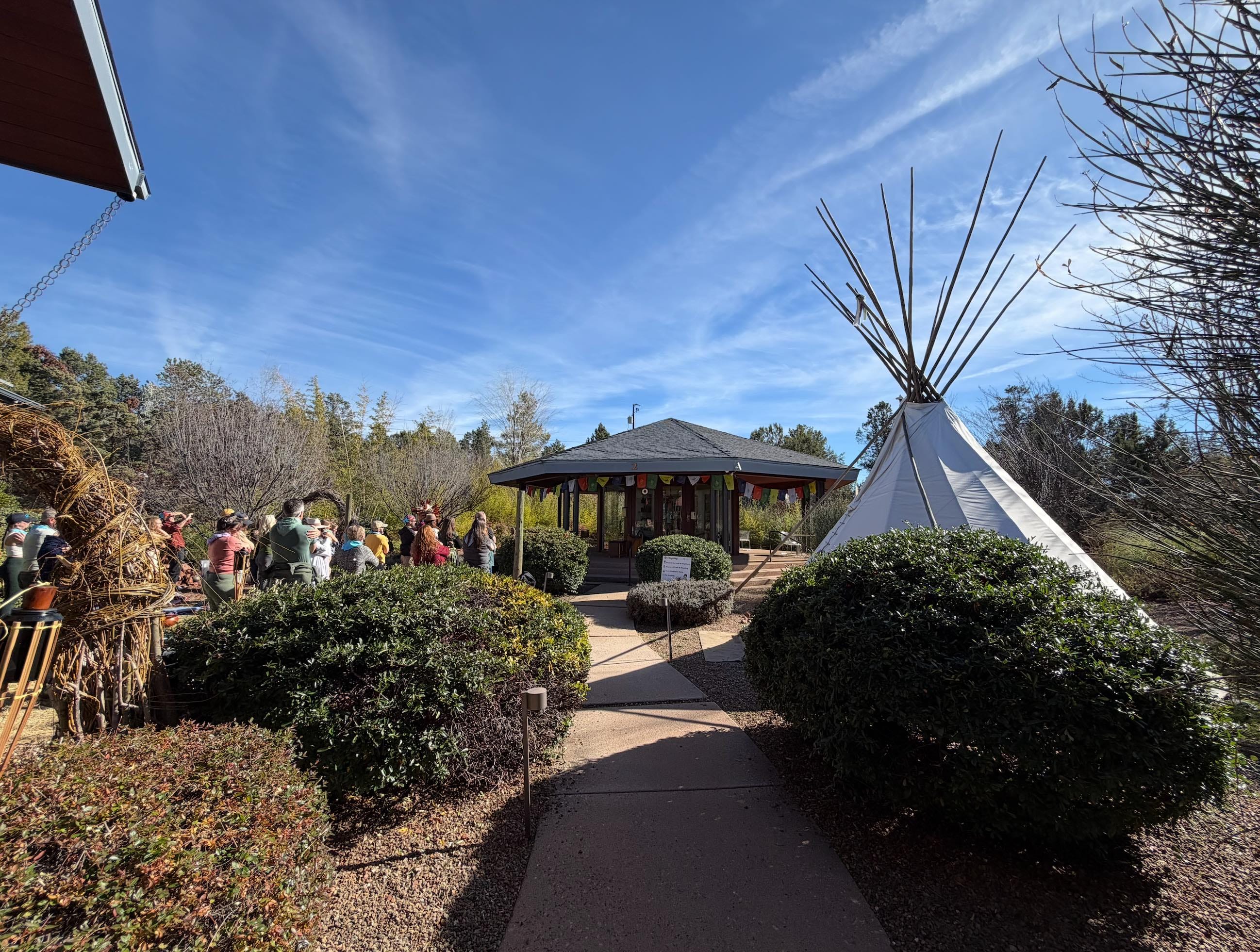 Guests gathered near the tipi and ceremony pavilion on a clear blue-sky day at Sedonya